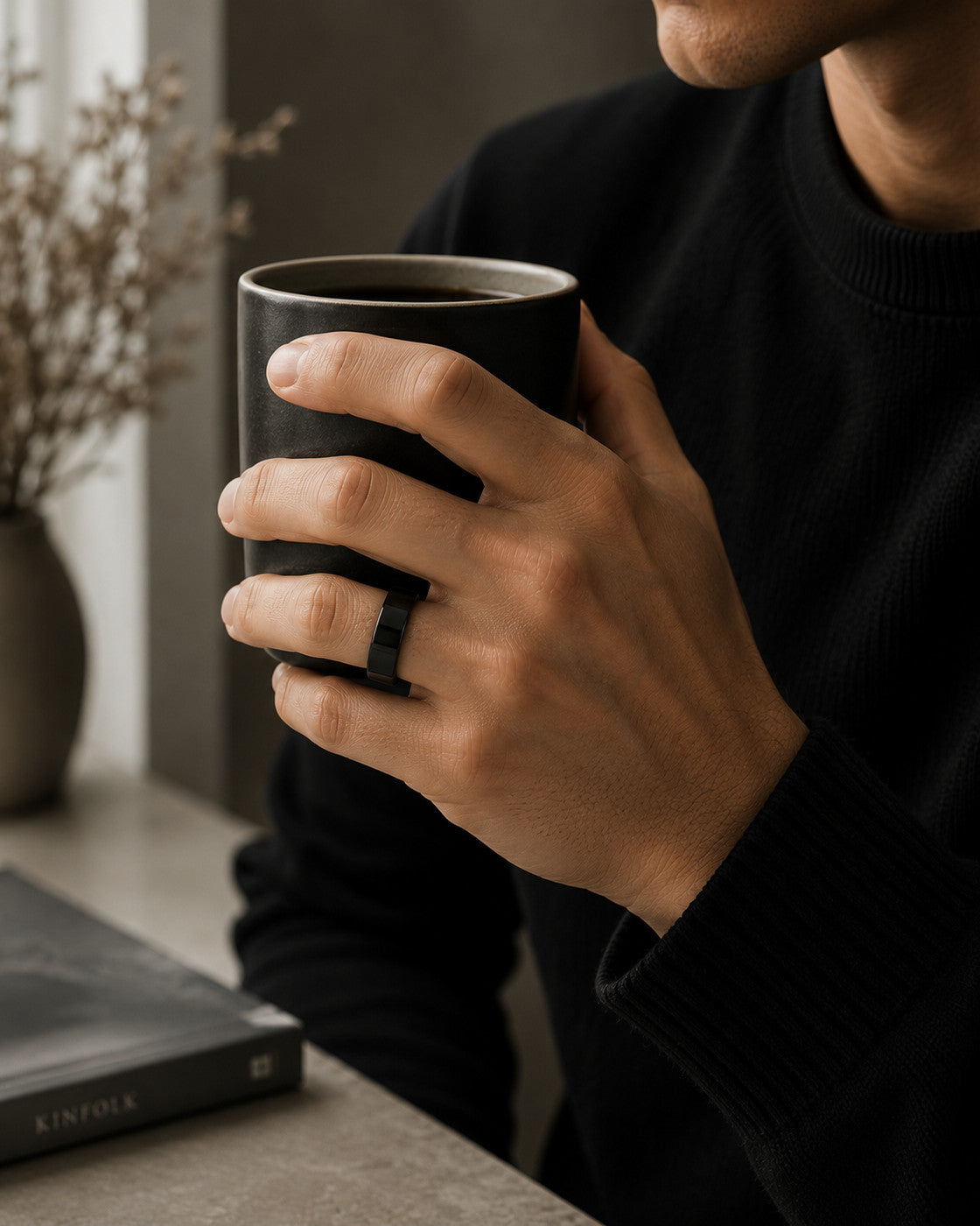 Kayza PRO black smart ring worn while holding a coffee cup