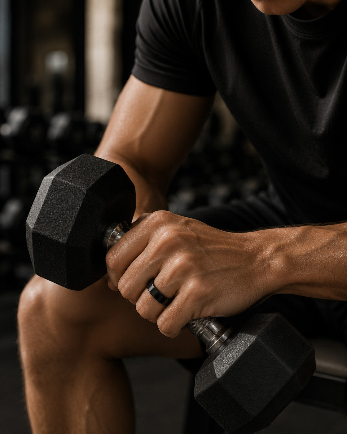 Kayza PRO black smart ring worn during dumbbell training in the gym