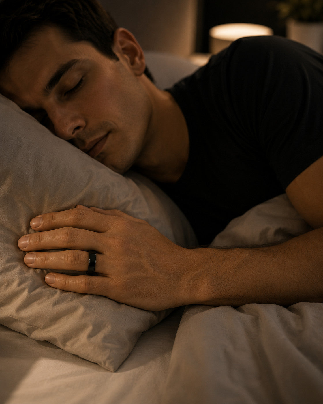 Man asleep wearing the Kayza PRO black smart ring for overnight sleep tracking