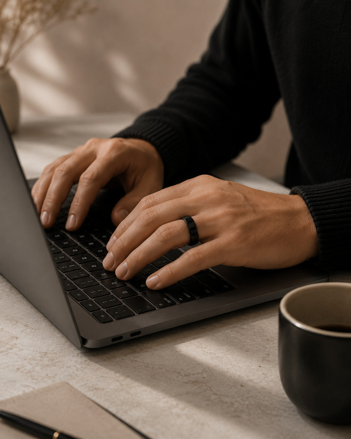 Kayza PRO black smart ring worn while typing at a laptop