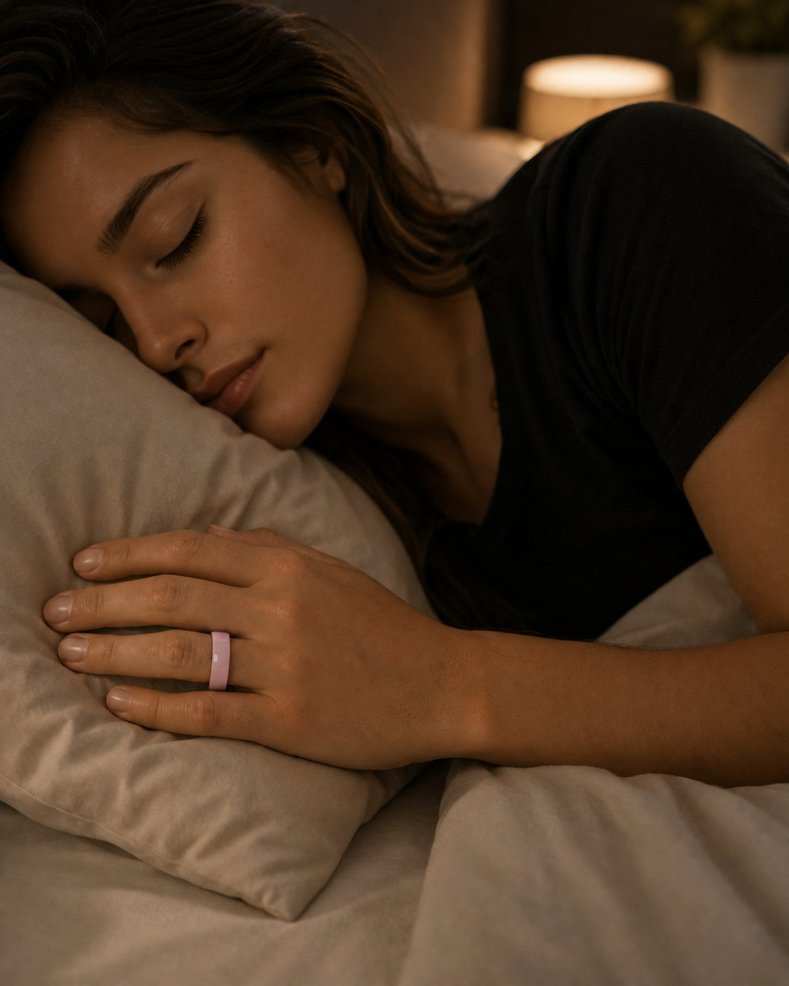 Woman asleep wearing the Kayza PRO pink smart ring for overnight sleep tracking