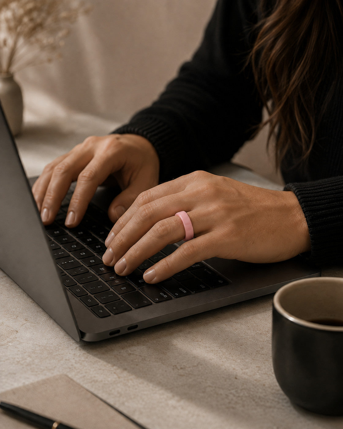 Kayza PRO pink smart ring worn while typing at a laptop
