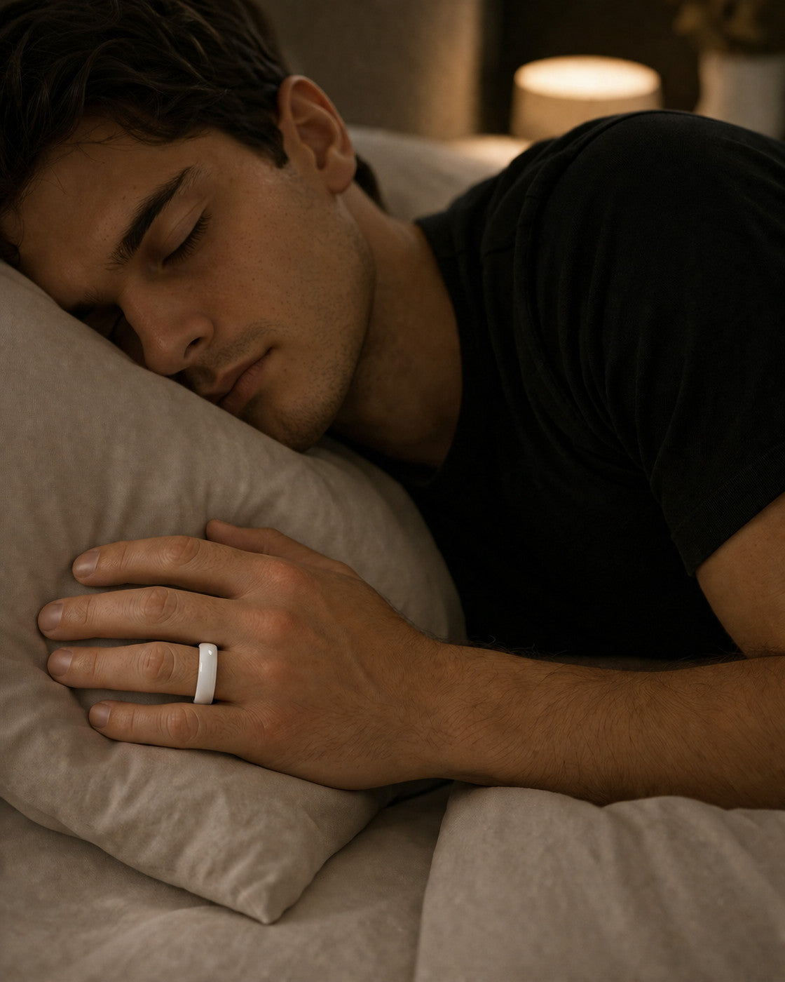 Man asleep wearing the Kayza PRO white smart ring for overnight sleep tracking